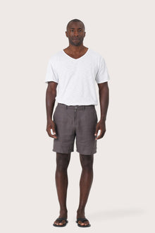 Model wearing the grey brown linen Kama bermuda shorts by By The Sea Bali