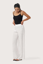 Side profile of the Kerang Linen Pant Off White showing its cut and natural movement.