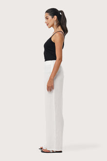 Side profile of the Kerang Linen Pant Off White showing its cut and natural movement.