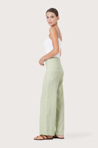 Side profile of the Kerang Linen Pant Green showing its cut and natural movement.