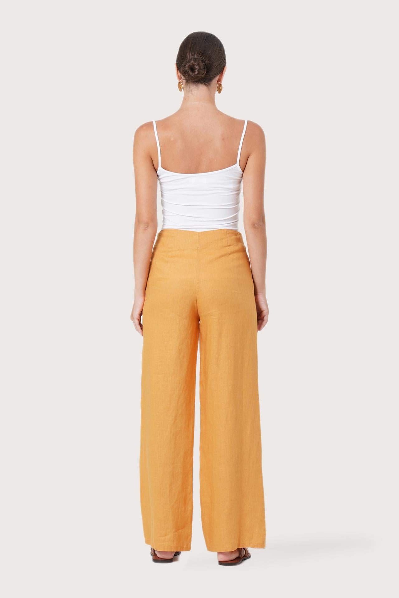Back view of the Kerang Women's Linen Pants Orange highlighting the garment shape and drape.