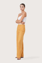 Side profile of the Kerang Women's Linen Pants Orange showing its cut and natural movement.