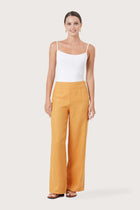 Woman wearing the Kerang Women's Linen Pants Orange designed for effortless resortwear and tropical living by By The Sea Bali.