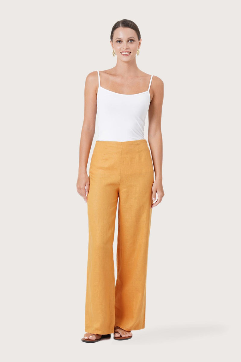 Woman wearing the Kerang Women's Linen Pants Orange designed for effortless resortwear and tropical living by By The Sea Bali.
