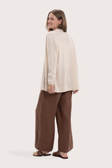 Back view of the natural cashmere outerwear with a relaxed and elegant silhouette