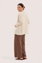 Back view of a woman wearing the natural cashmere Klarr outerwear
