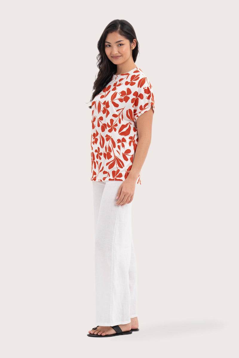 Side profile of the Lenore Printed Top Flower Dark Orange showing its cut and natural movement.