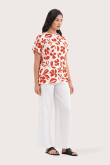 Side profile of the Lenore Printed Top Flower Dark Orange showing its cut and natural movement.