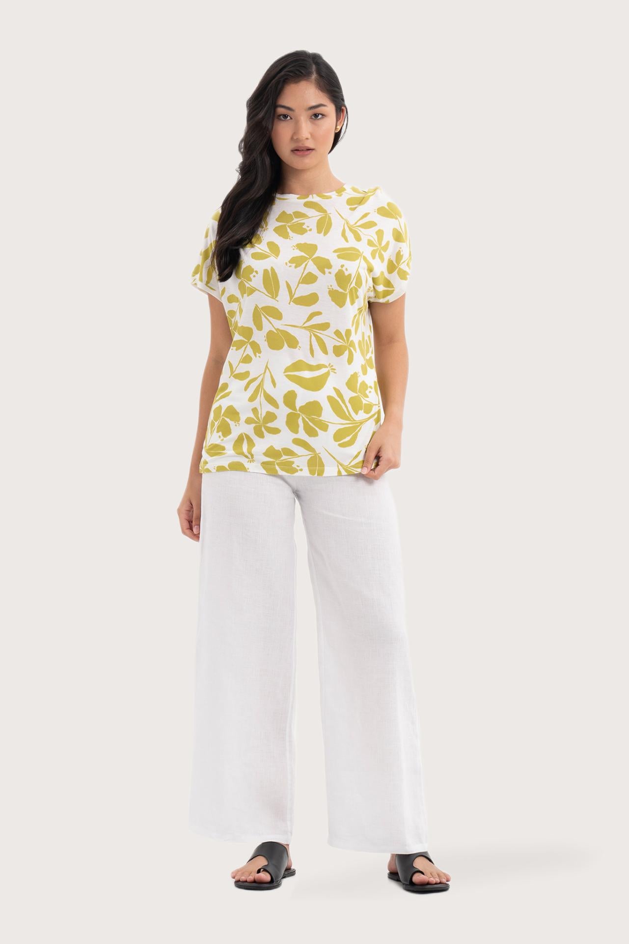 Woman wearing the Lenore Printed Top Flower Green designed for effortless resortwear and tropical living, by the sea bali.