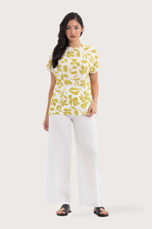 Woman wearing the Lenore Printed Top Flower Green designed for effortless resortwear and tropical living, by the sea bali.