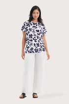 Woman wearing the Lenore Printed Top Flower Purple designed for effortless resortwear and tropical living, by By The Sea Bali.