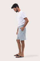Side profile of the light blue linen bermuda shorts showcasing their effortless fit