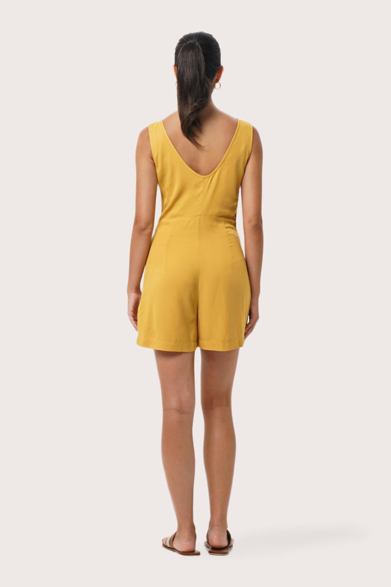 Back view of the Lisa Playsuit Mustard highlighting the garment shape and drape