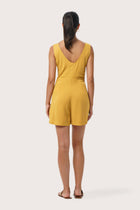 Back view of the Lisa Playsuit Mustard highlighting the garment shape and drape