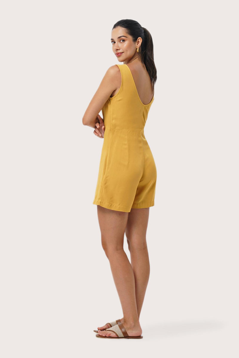 Side profile of the Lisa Playsuit Mustard showing its cut and natural movement