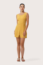 Woman wearing the Lisa Playsuit Mustard designed for effortless resortwear and tropical living by By The Sea Bali