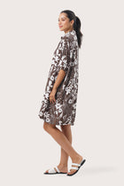 Side profile of the Lupita Midi Dress Brown showing its cut and natural movement