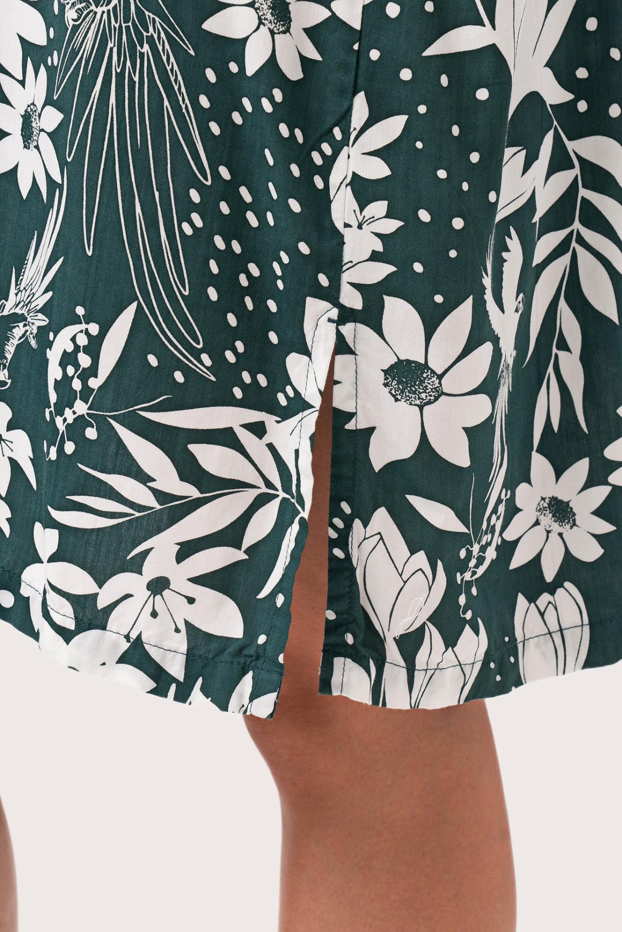 Close up detail of the Lupita Midi Dress Green highlighting craftsmanship and slit design features