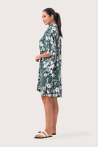 Side profile of the Lupita Midi Dress Green showing its cut and natural movement