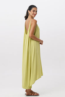 Side profile of the Mala Lowback Maxi Dress Lime Green showing its cut and natural movement
