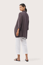 Back view of the Maluku Outerwear Ash highlighting the garment shape and drape