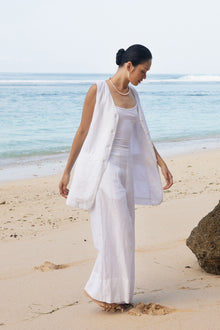 Women's white linen vest styled for tropical holidays, beach vacations and sophisticated resort fashion by By The Sea Bali