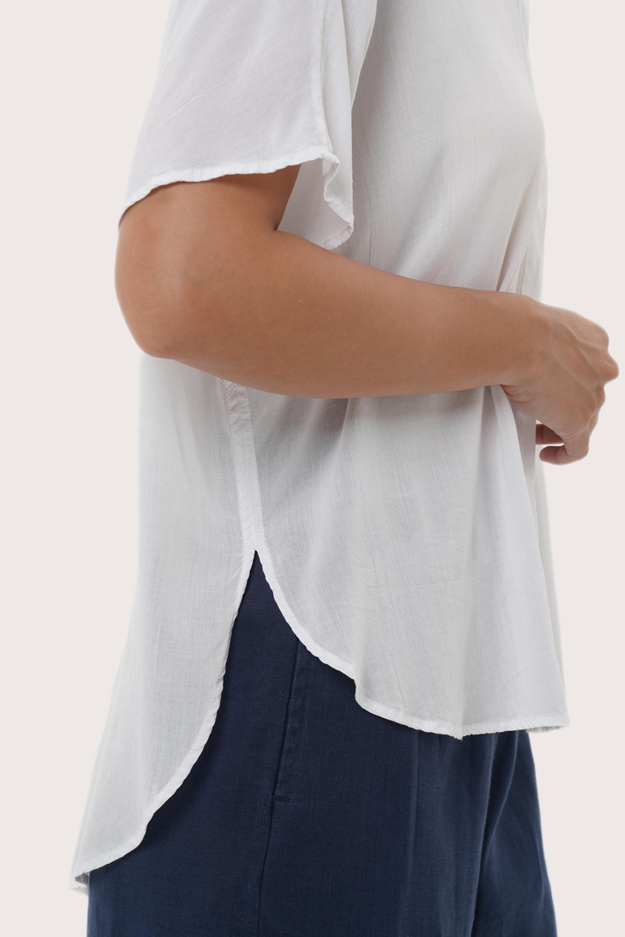 Close-up of the Marina Shirt White Linen's hem highlighting clean stitching and durable garment finishing.