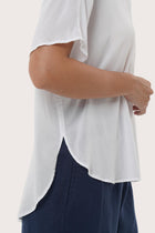 Close-up of the Marina Shirt White Linen's hem highlighting clean stitching and durable garment finishing.