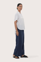 Side profile of the Marina Linen Shirt White showing its cut and natural movement.
