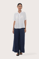 Woman wearing the Marina Linen Shirt White designed for effortless resortwear and tropical living by By The Sea Bali.