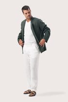 Side profile of the dark green linen jacket showcasing its comfortable fit and effortless drape