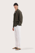 Side profile of the dark green linen jacket showcasing its comfortable fit and effortless drape
