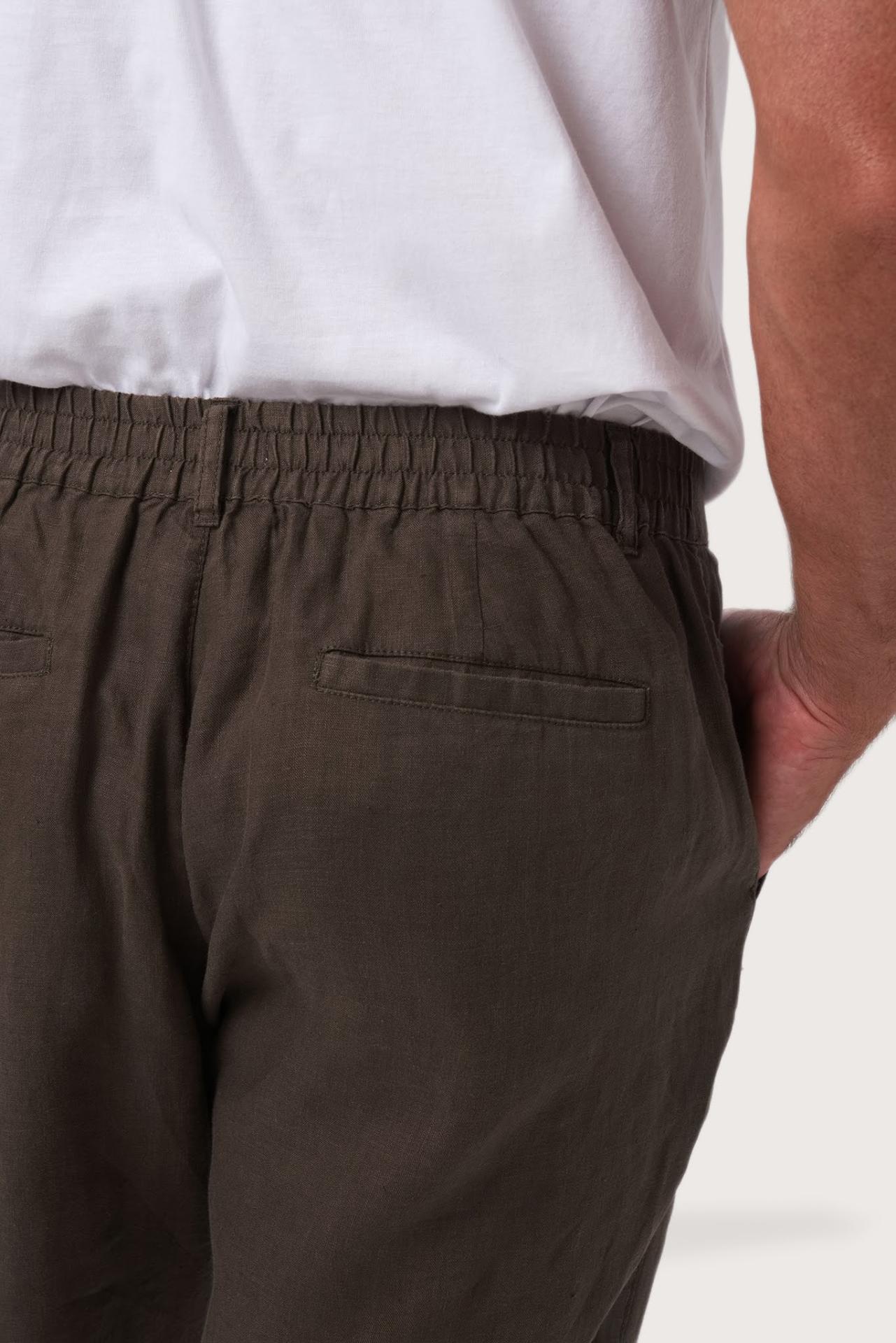 Back pocket detail of the Chocolate Maury Linen Long Pant revealing its refined linen tailoring by By The Sea Bali