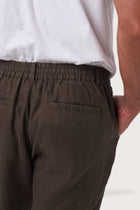 Back pocket detail of the Chocolate Maury Linen Long Pant revealing its refined linen tailoring by By The Sea Bali