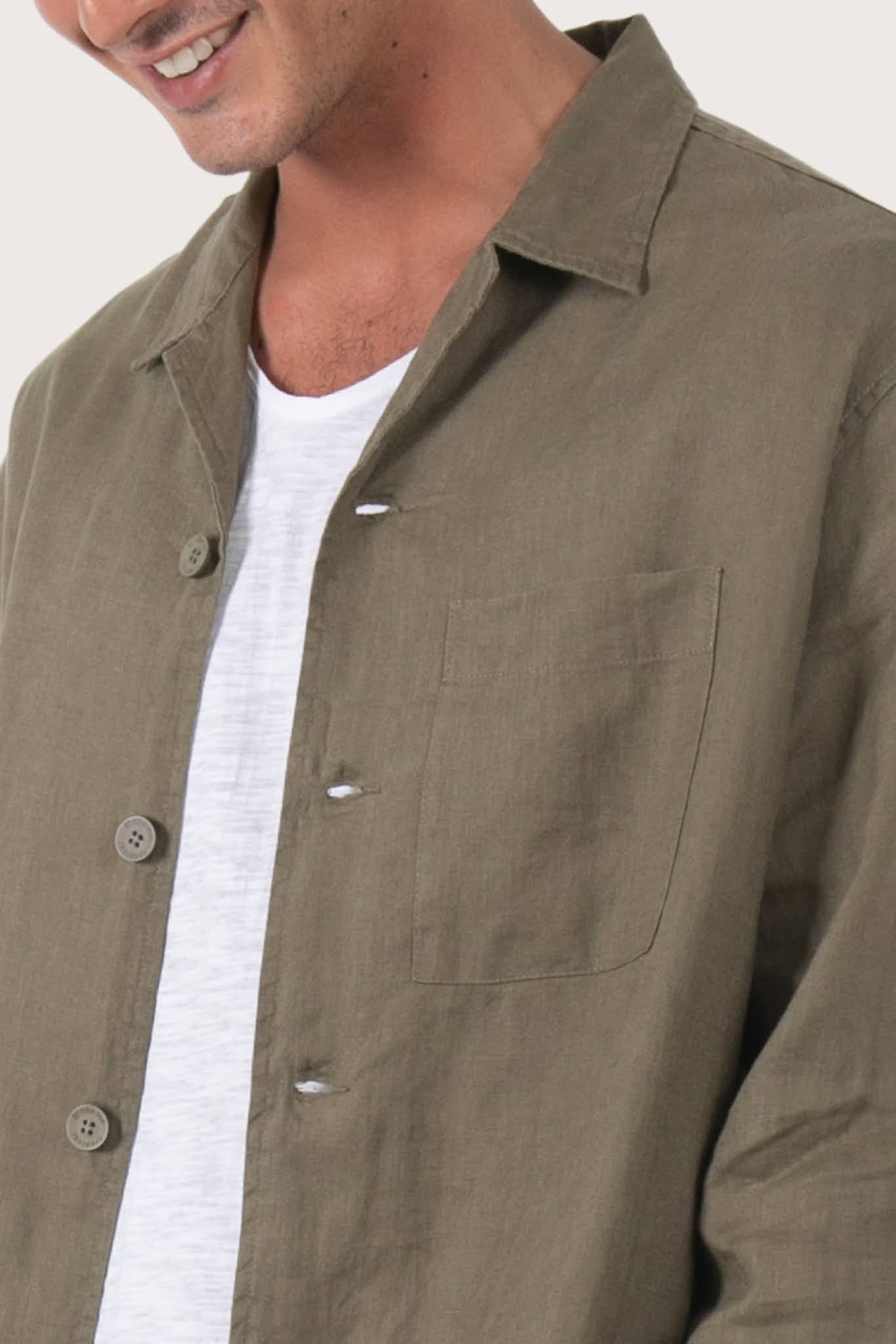 Close-up of the linen fabric texture and refined tailoring details on the brown jacket