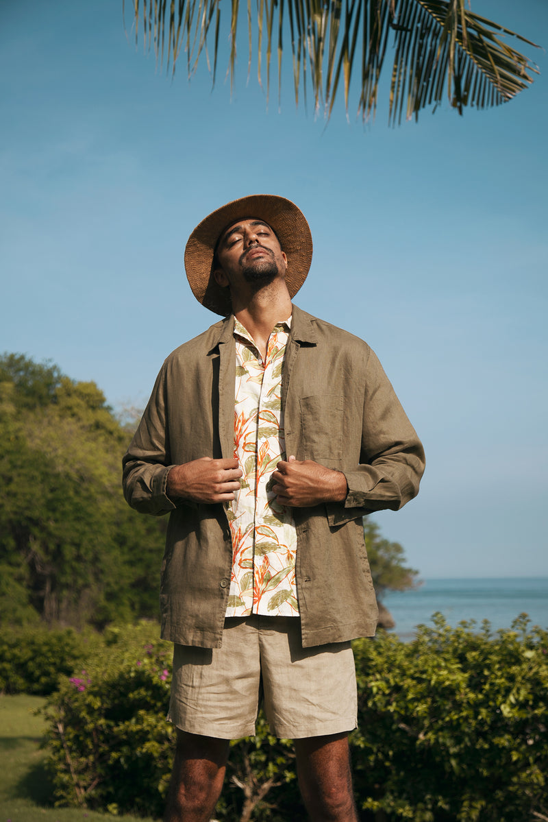 Man wearing the brown linen Maverick jacket in a tropical resort setting