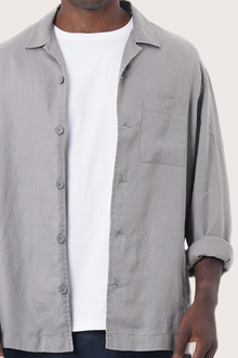 Close-up of the linen fabric texture and refined tailoring details on the grey jacket