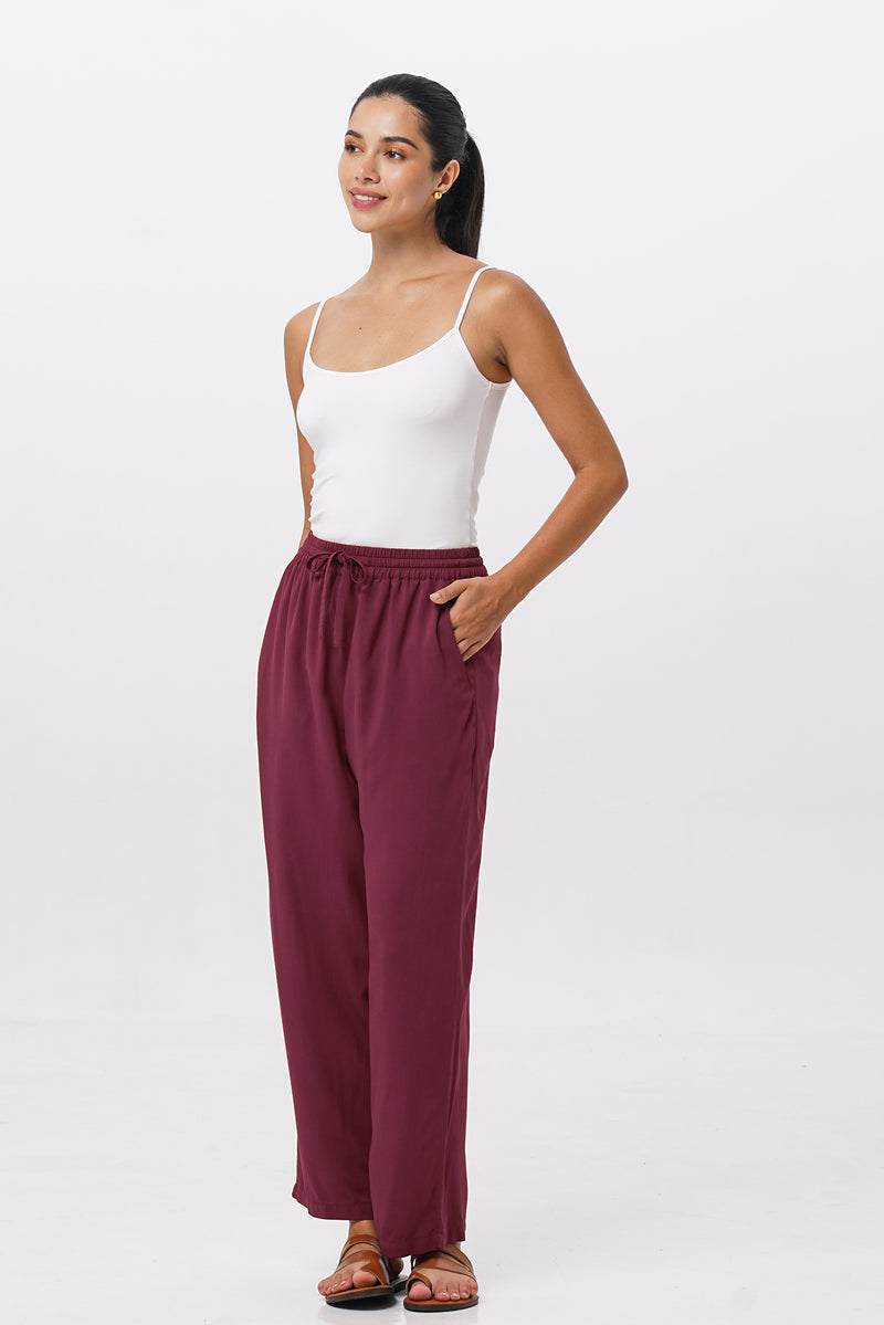 Woman wearing the Maya Drawstring Pants Brick designed for effortless resortwear and tropical living by By The Sea Bali.