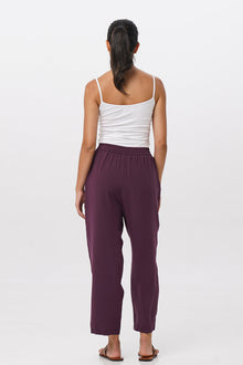 Back view of the Maya Drawstring Pants Dark Purple highlighting the garment shape and drape.