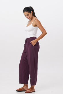 Side profile of the Maya Drawstring Pants Dark Purple showing its cut and natural movement.