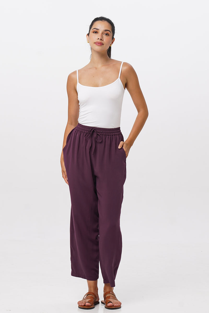 Woman wearing the Maya Drawstring Pants Dark Purple designed for effortless resortwear and tropical living by By The Sea Bali.