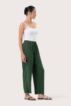 Side profile of the Maya Drawstring Pants Forest Green showing its cut and natural movement.