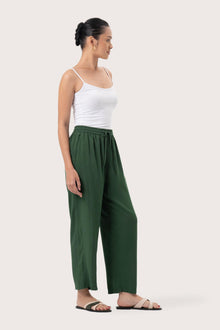 Side profile of the Maya Drawstring Pants Forest Green showing its cut and natural movement.