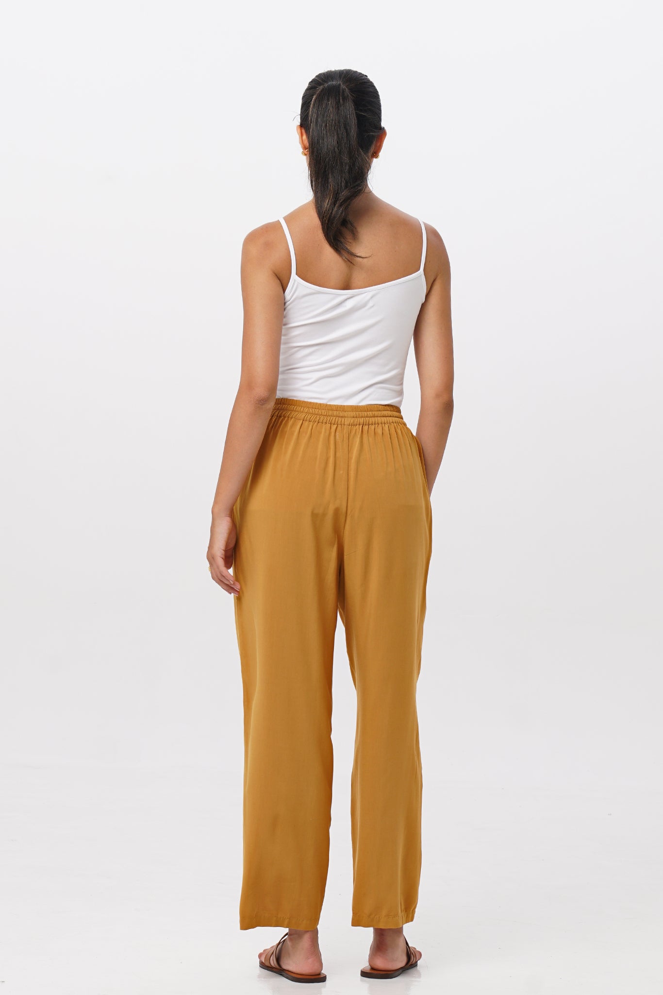 Back view of the Maya Drawstring Pants Mustard highlighting the garment shape and drape.