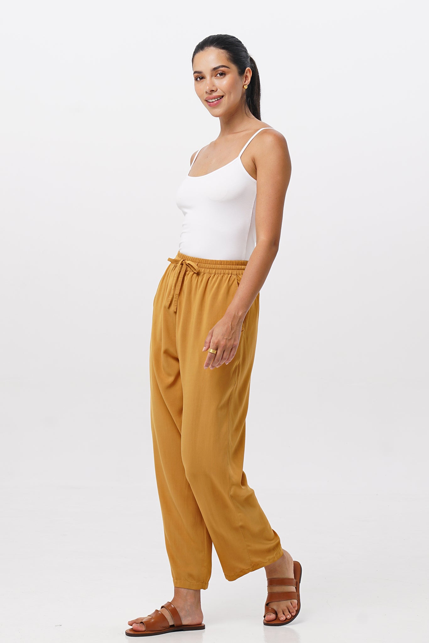 Side profile of the Maya Drawstring Pants Mustard showing its cut and natural movement.