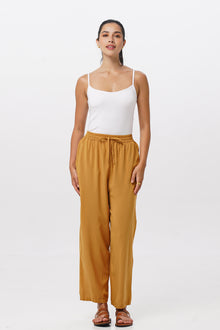 Woman wearing the Maya Drawstring Pants Mustard designed for effortless resortwear and tropical living by By The Sea Bali.