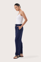 Side profile of the Maya Drawstring Pants Navy showing its cut and natural movement.