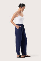 Side profile of the Maya Drawstring Pants Navy showing its cut and natural movement.