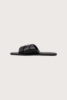 Side profile of Milos sandal in nero highlighting sleek and modern resort footwear silhouette