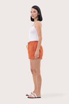 Side view of the Miwa Linen Short Coral showcasing its silhouette and relaxed fit
